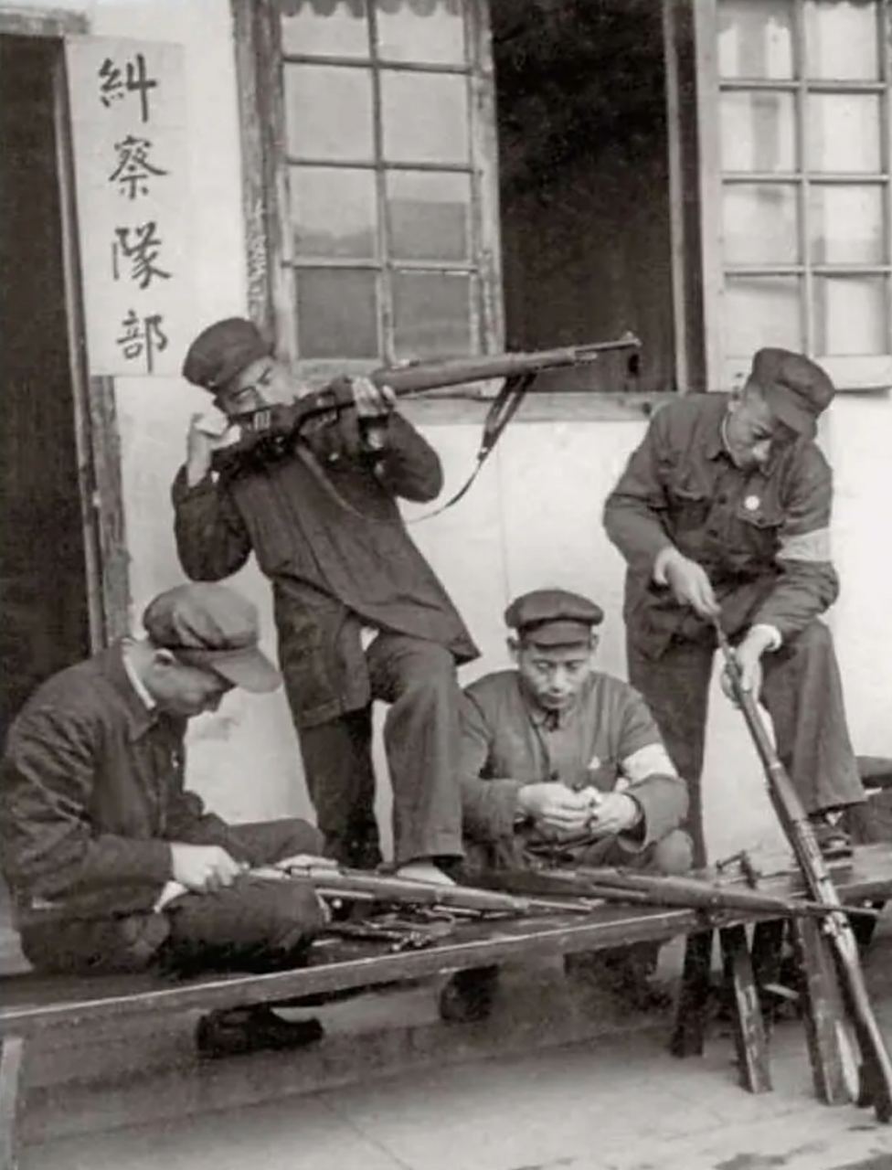 1950年上海协助维持社会秩序的工人纠察队在检查q支,保持装备干净,不