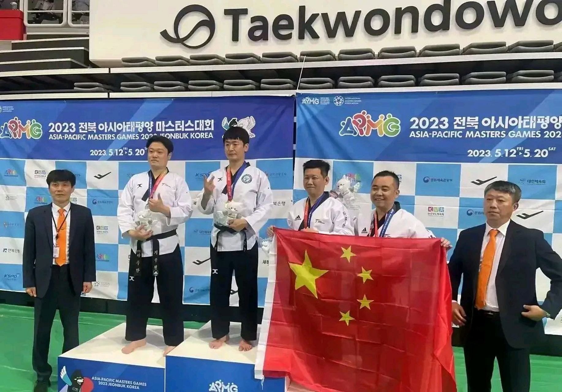 在韩国的跆拳道比赛中,中国台湾地区的运动员李东宪获得铜牌,颁奖时