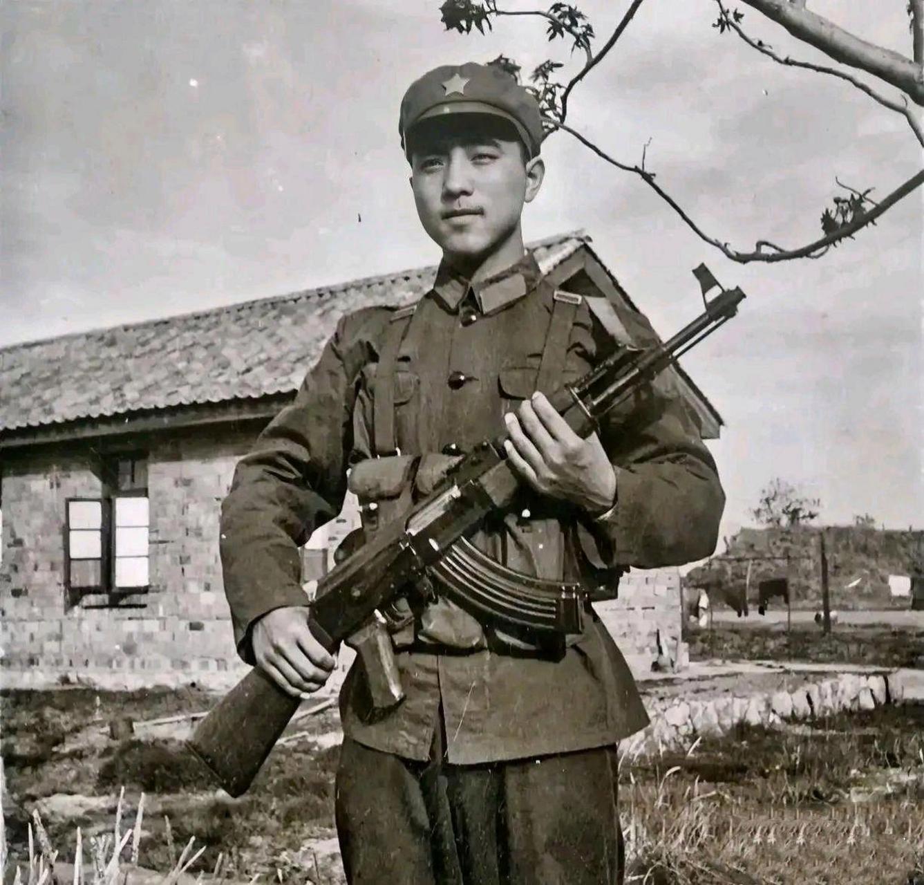 一名年轻的解放军战士,他穿着整齐的军装,拿着一把冲锋枪正在值岗