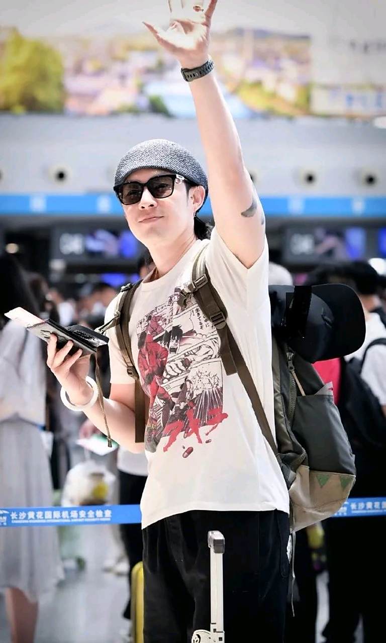 吴建豪亮相上海机场,他以漫画风t恤搭配黑色运动裤,脚踩运动鞋的造型