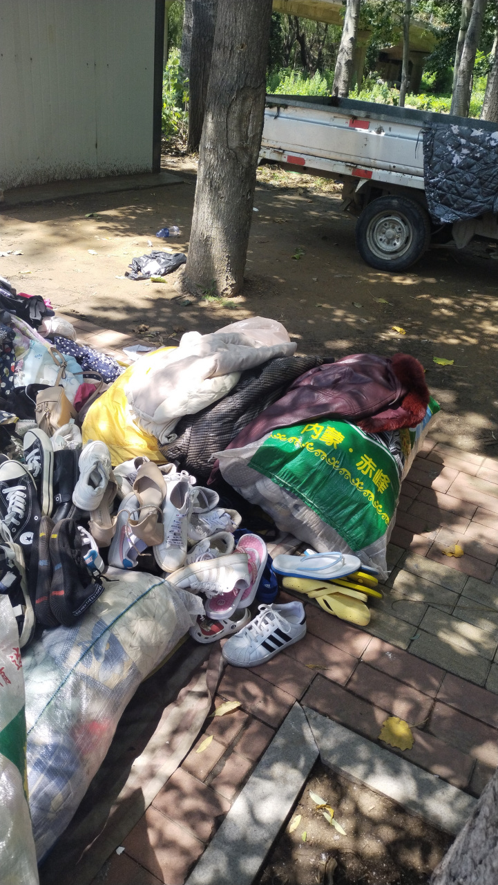 周日旧物市场热闹非凡,路过收旧衣服的摊位,看摊主边忙碌地筛选着各种