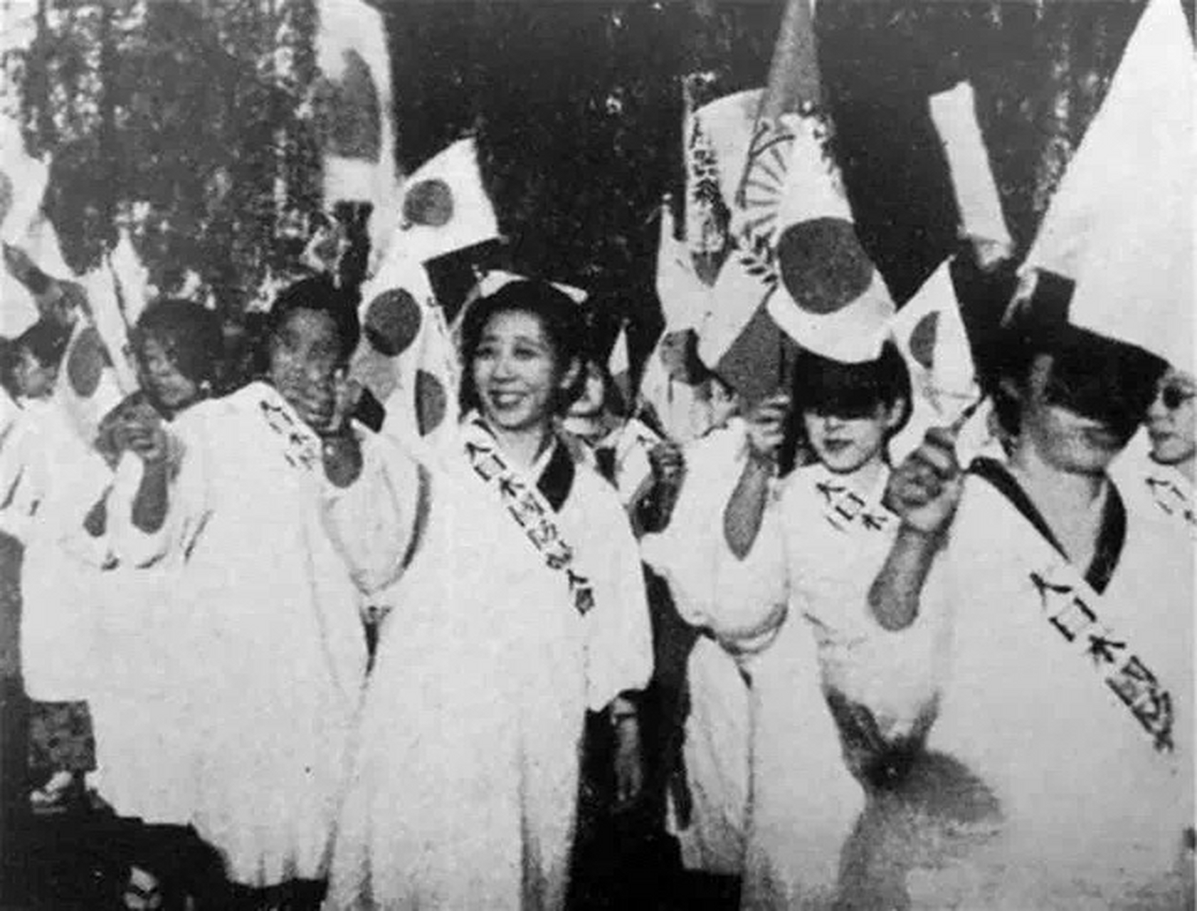 这是1937年,日军占领南京后,日本国防妇人会的女性纷纷走上大街,举着