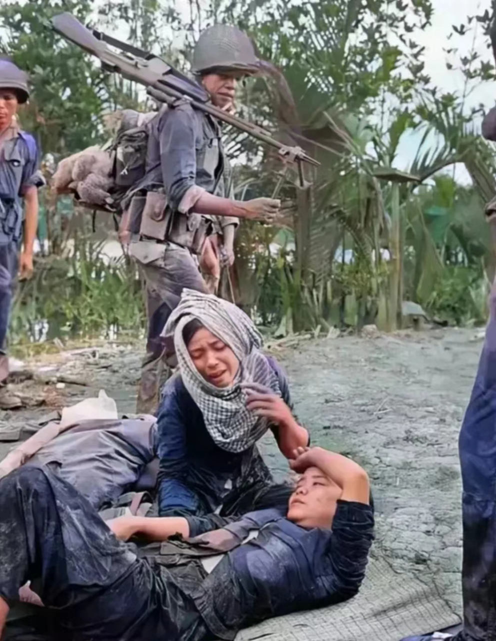1965年,越战期间,一名受伤的越南女兵躺在地上,她的母亲泪眼朦胧地