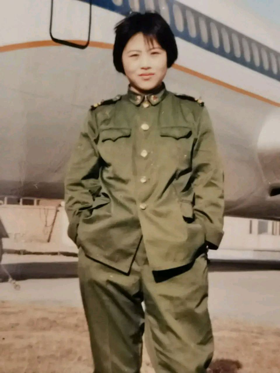 1990年,成都太平寺机场,一位身穿军装的女兵面对镜头露出了阳光般的