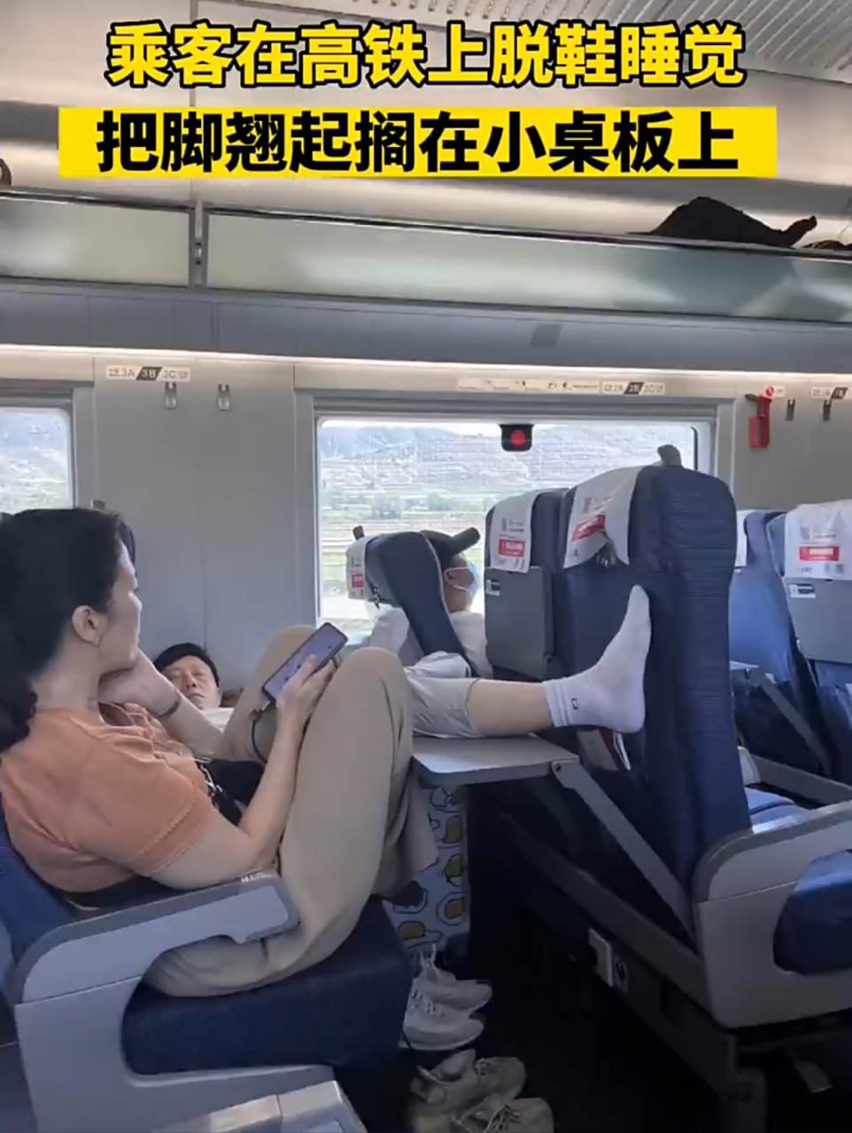 乘客在高铁上脱鞋睡觉把脚翘起搁在小桌板上.#社会百态