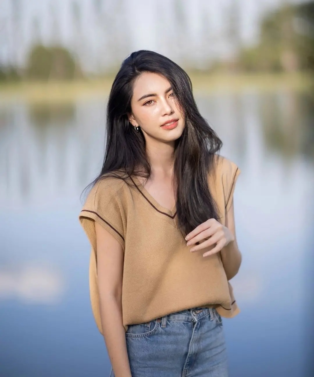 mai davika身穿棕色针织背心搭配牛仔裤,气质优雅