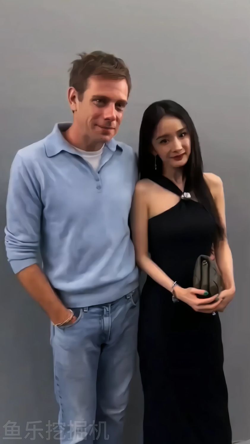 当杨幂跟老外合影,老外的手搂着杨幂的腰,杨幂微微歪头靠向老外的肩膀