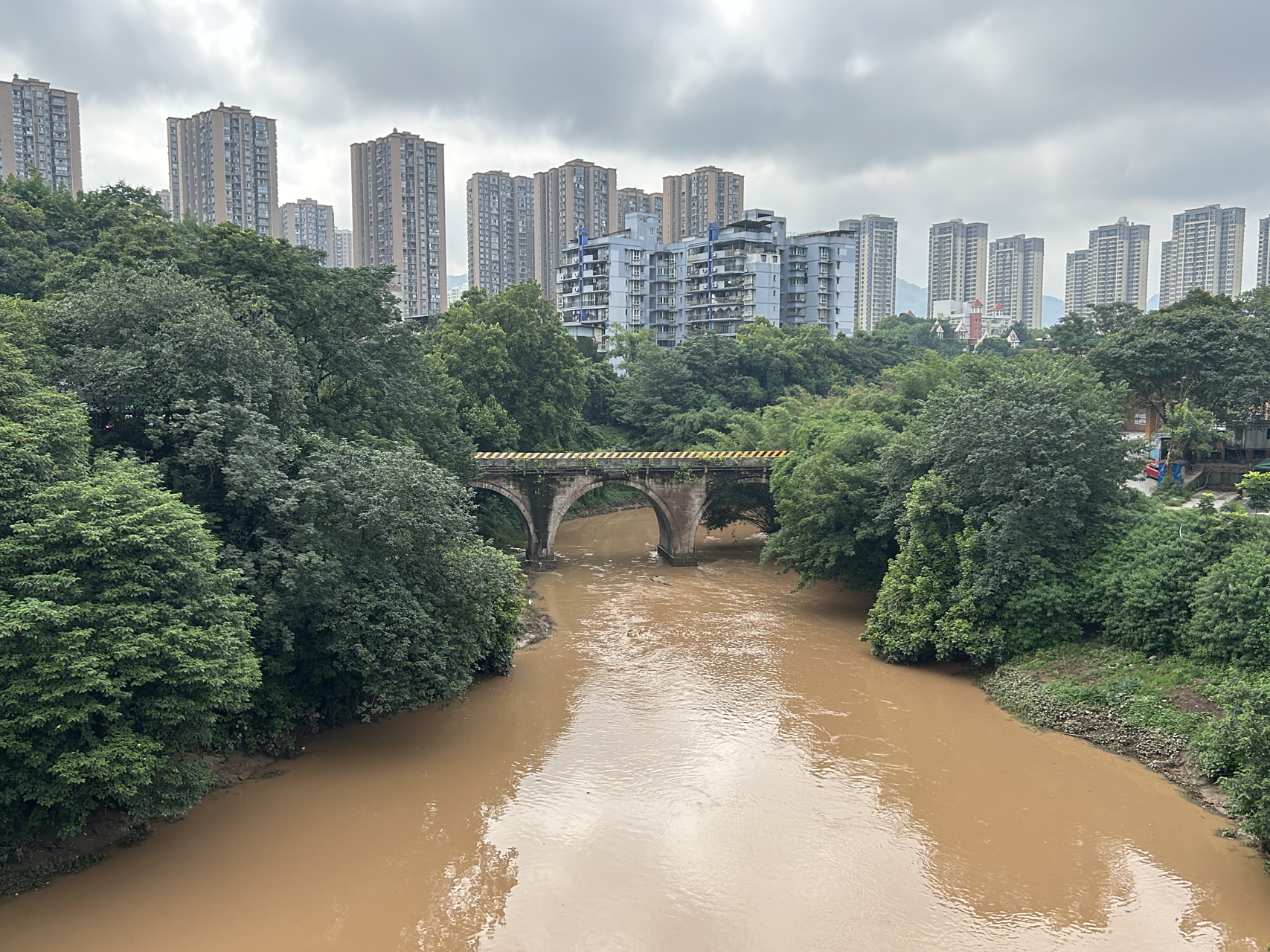在重庆巴南区,一座小型拱桥横跨于花溪河上,它一共有三个桥洞,隐藏在