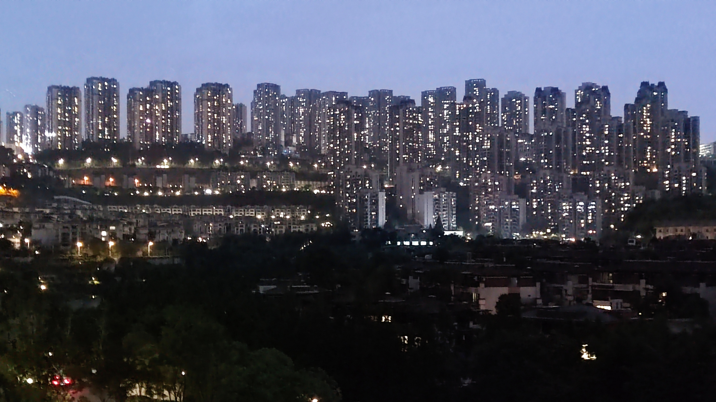 重庆照母山的肖家沟水库附近,远处的高楼层层叠叠,夜幕之下星星点点