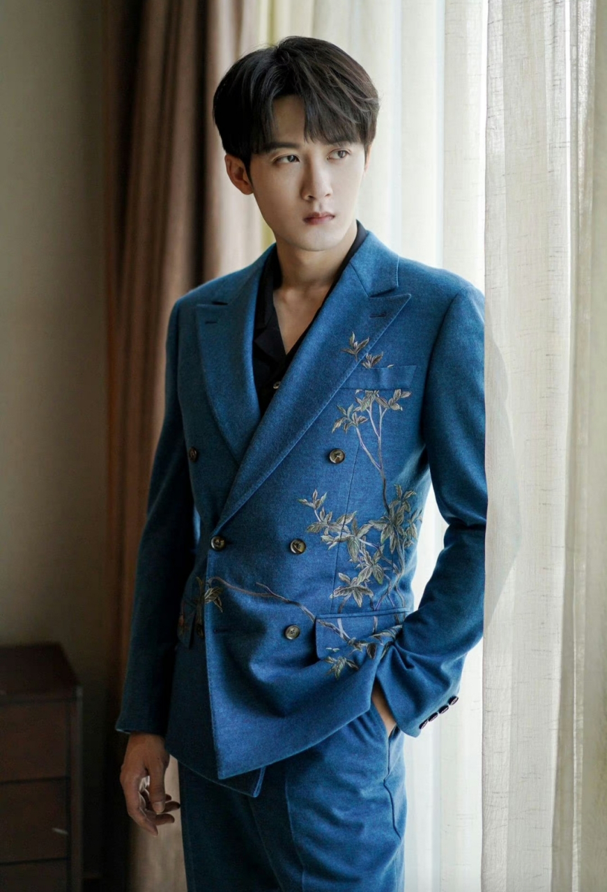 檀健次穿金色花纹刺绣点缀的蓝色西装,温润如玉,高贵典雅又不失帅气