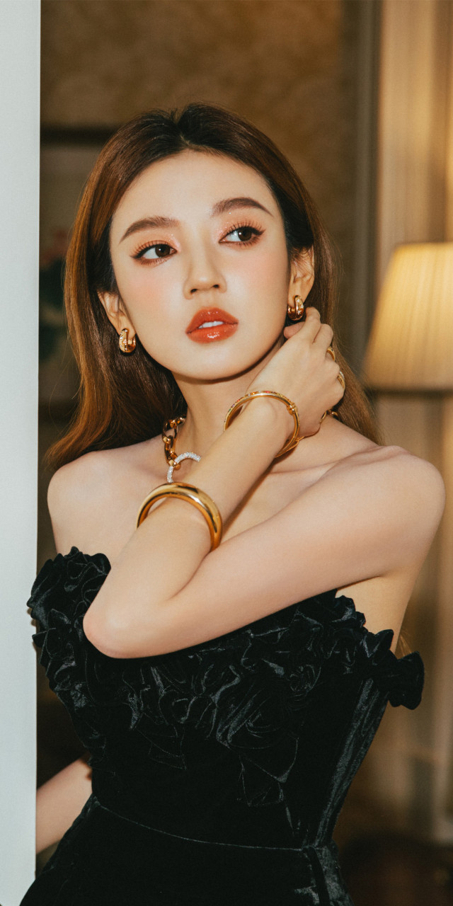 何瑞贤一身黑色抹胸裙,长发红唇,精致优雅