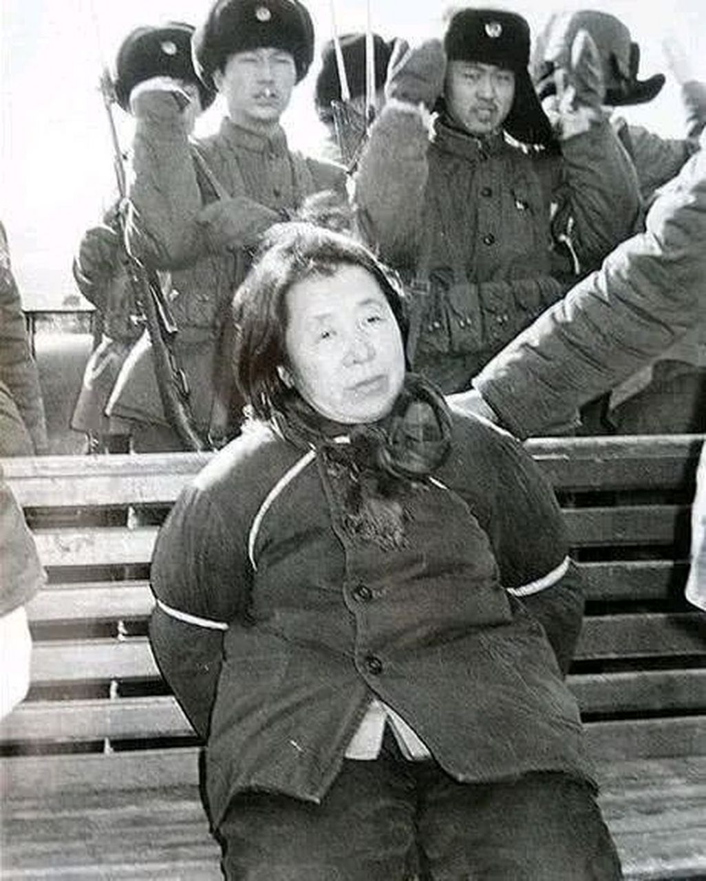 这是1980年哈尔滨郊外刑场,拍下的一张照片,镜头中这个坐在长凳上,被