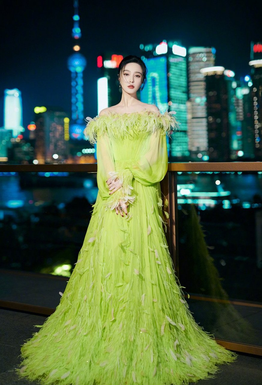 范冰冰身穿一件荧光绿露肩连衣裙礼服,高调颜色与羽毛元素结合在一起