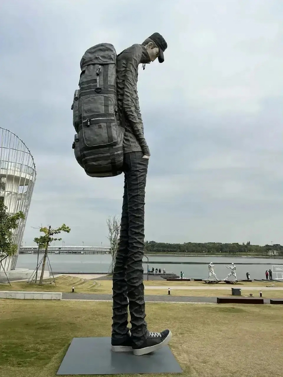 深圳人才公园这雕像,背着沉重的包袱,腰都压弯,低着头继续向前走.