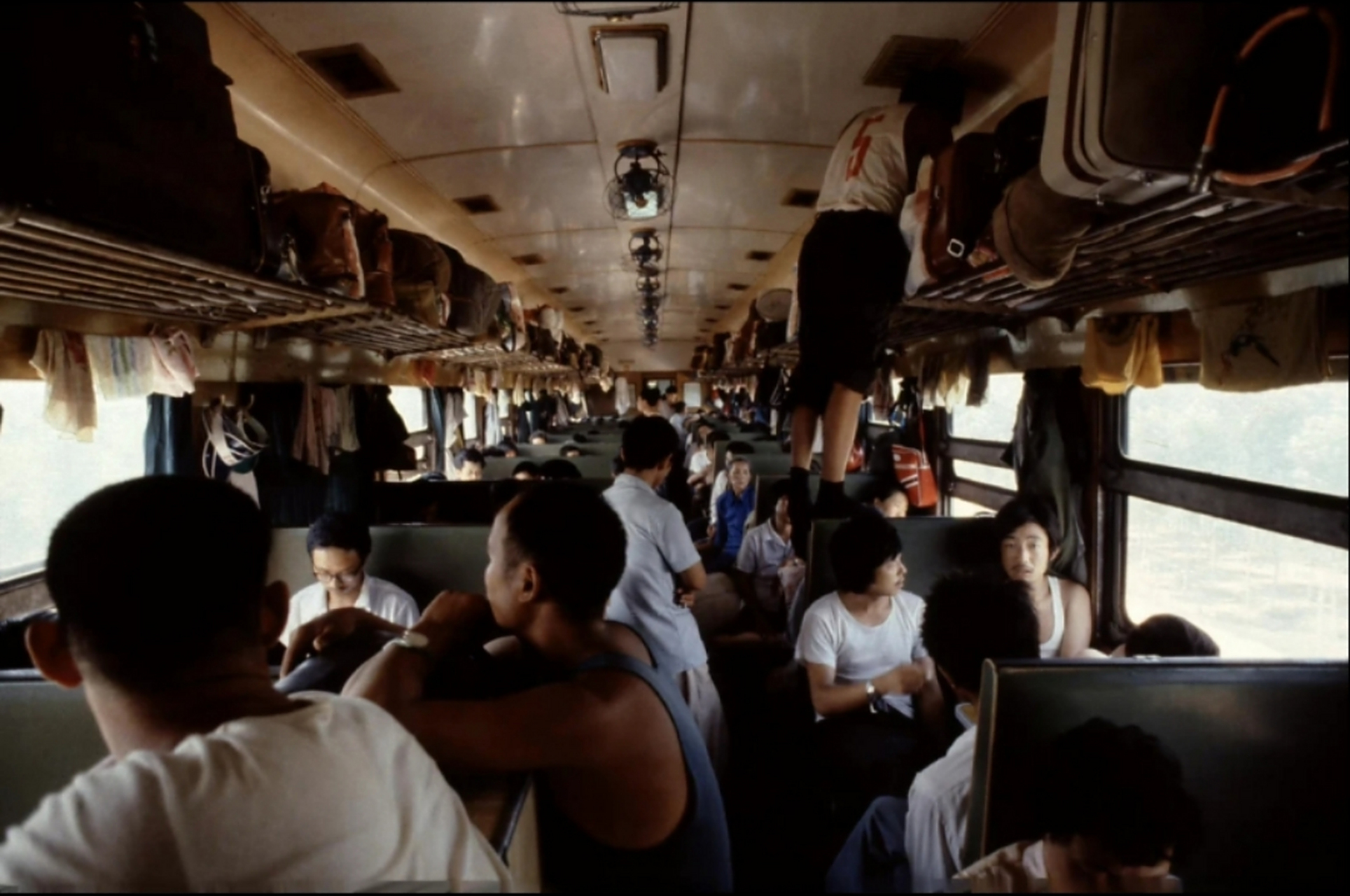 1985年,由京城开往成都的火车,这是硬座车厢,旅客很多,过道上都站满了