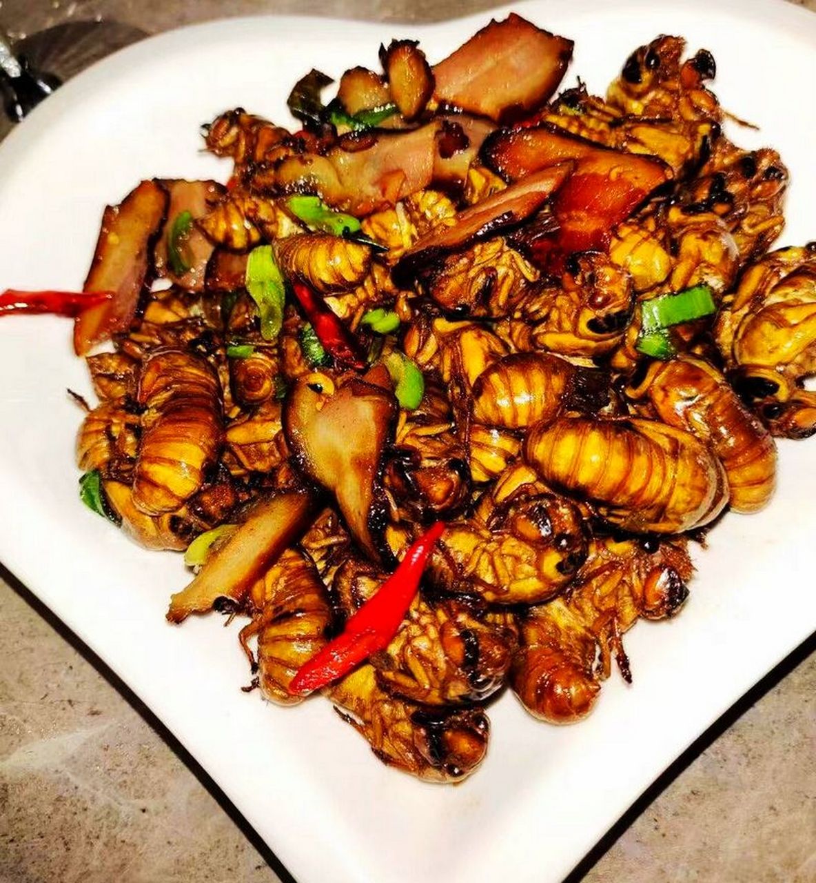 知了猴,一种富有蛋白质和营养的美味,经过多重工序后,搭配麻辣或腊肉