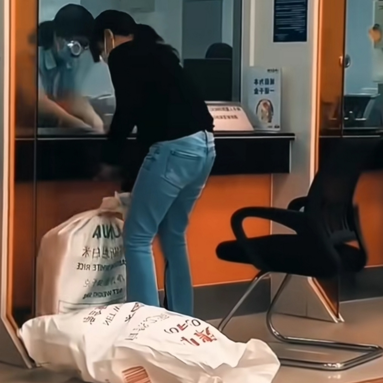 女子提着两个麻袋去银行存钱,当她拿出两捆百元大钞时,我的嘴角留下了