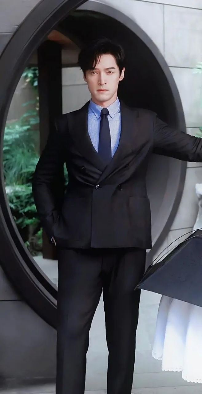 一身黑色西装内搭蓝色衬衫,显得胡歌帅气又干练.