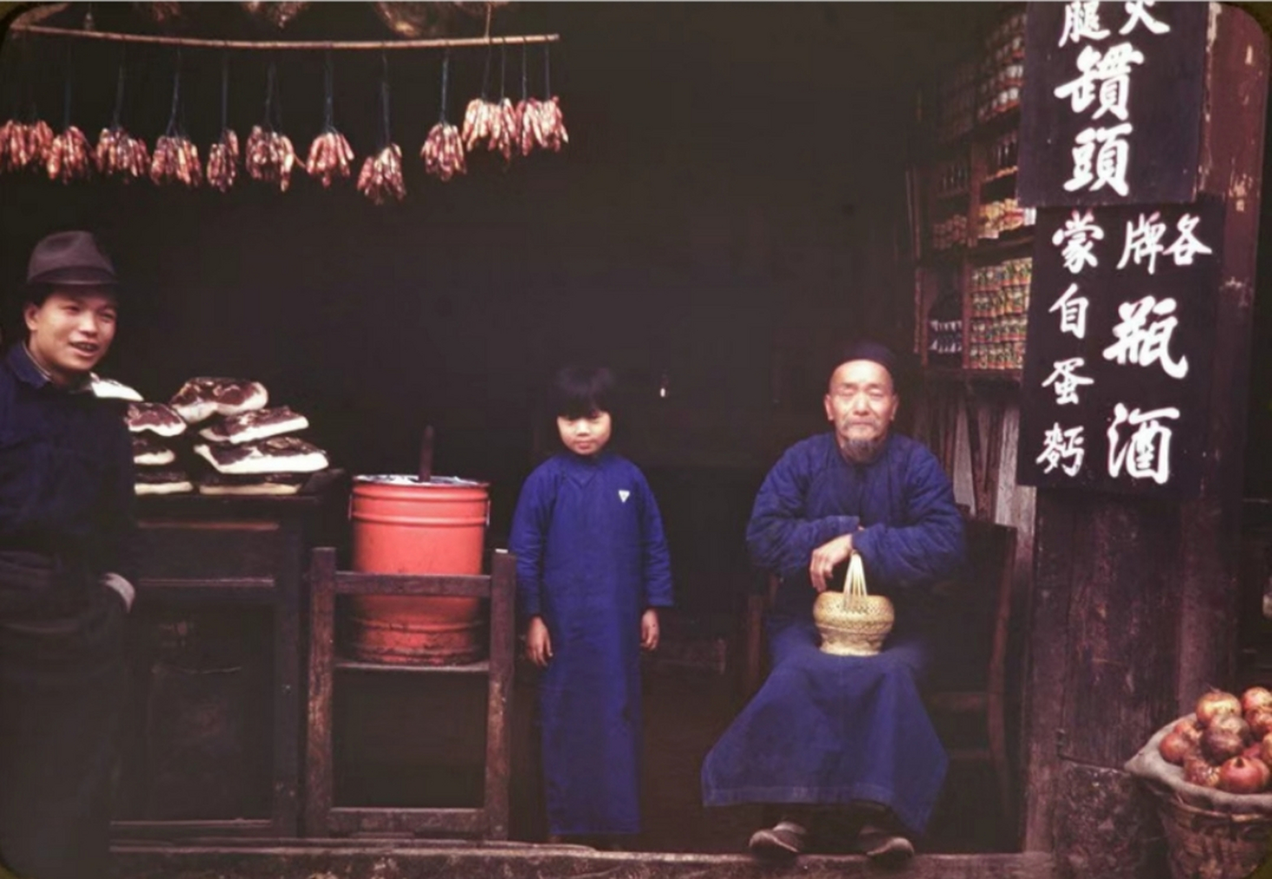 民国老照片,1945年11月,昆明的肉铺,老人和孩子都穿着长衫,态度平和