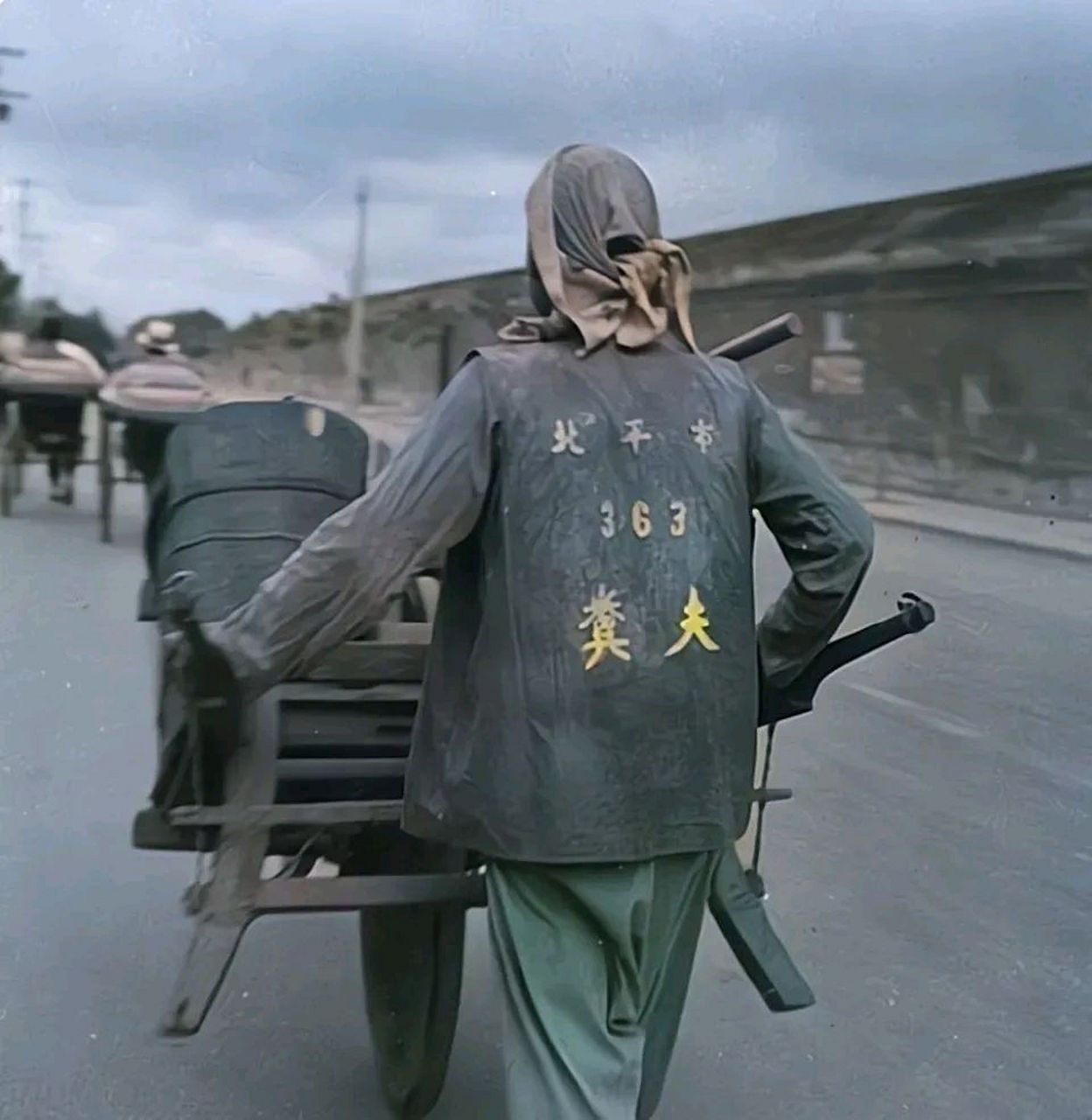 1935年,北平街头,一名拉粪工人正推着架子车,前去居民家里取粪,据记载