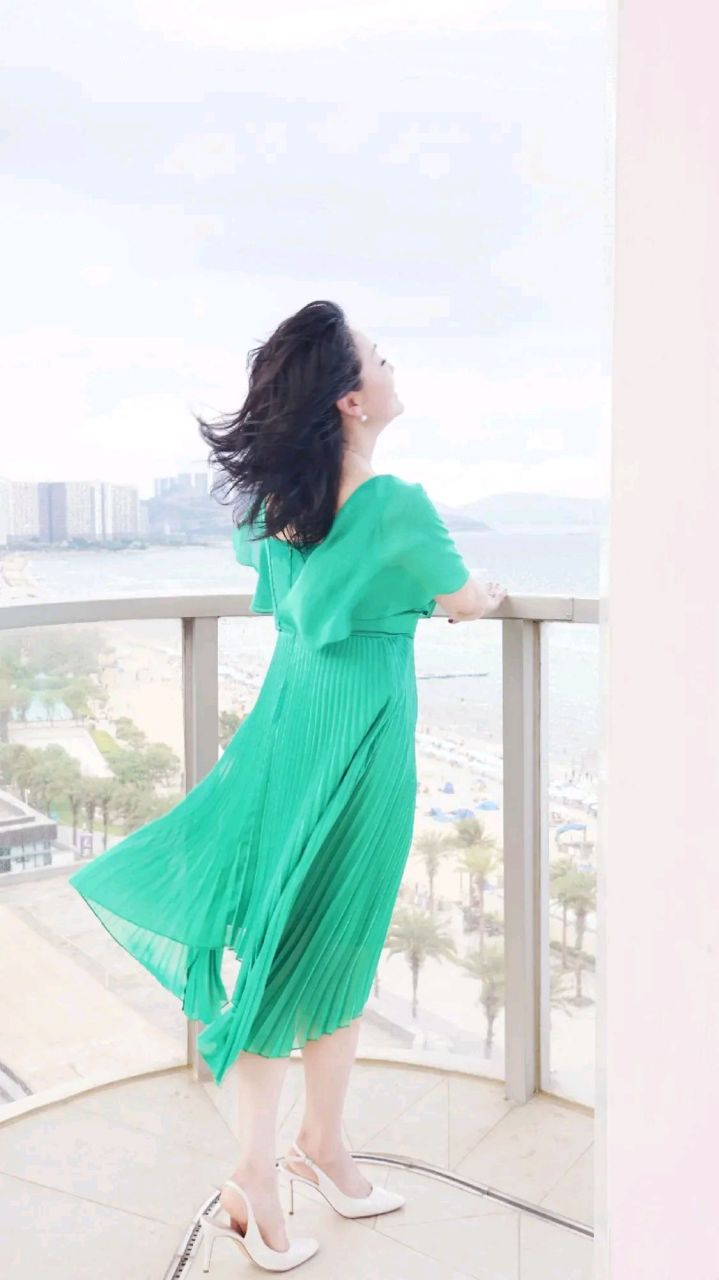 王姬在海边吹风,一袭绿色纱裙搭配白色高跟鞋,风情万种,优雅迷人,完全