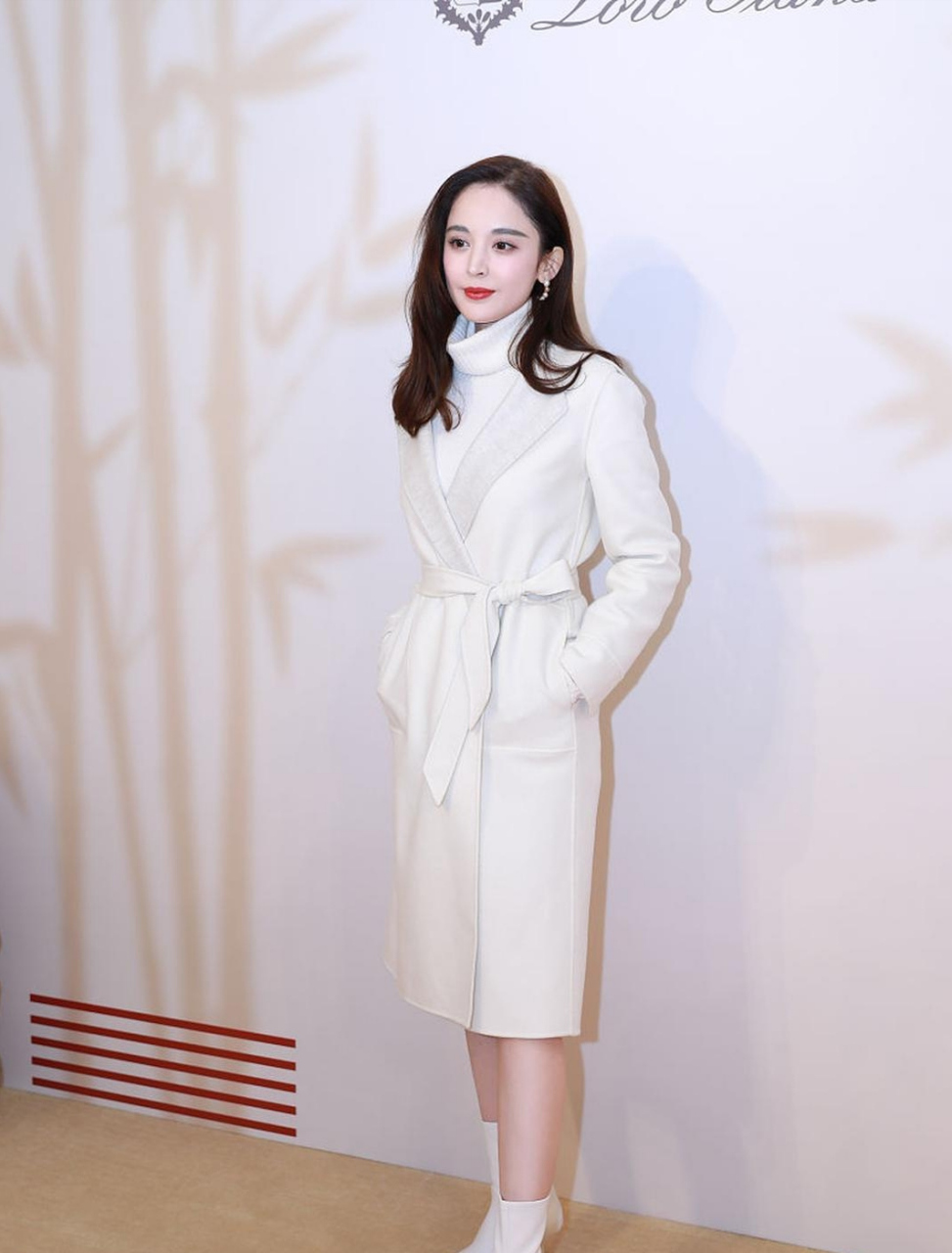 看古力娜扎长发披肩,穿着白色高领羊毛衫,撘配白色腰带裙,肤白貌美