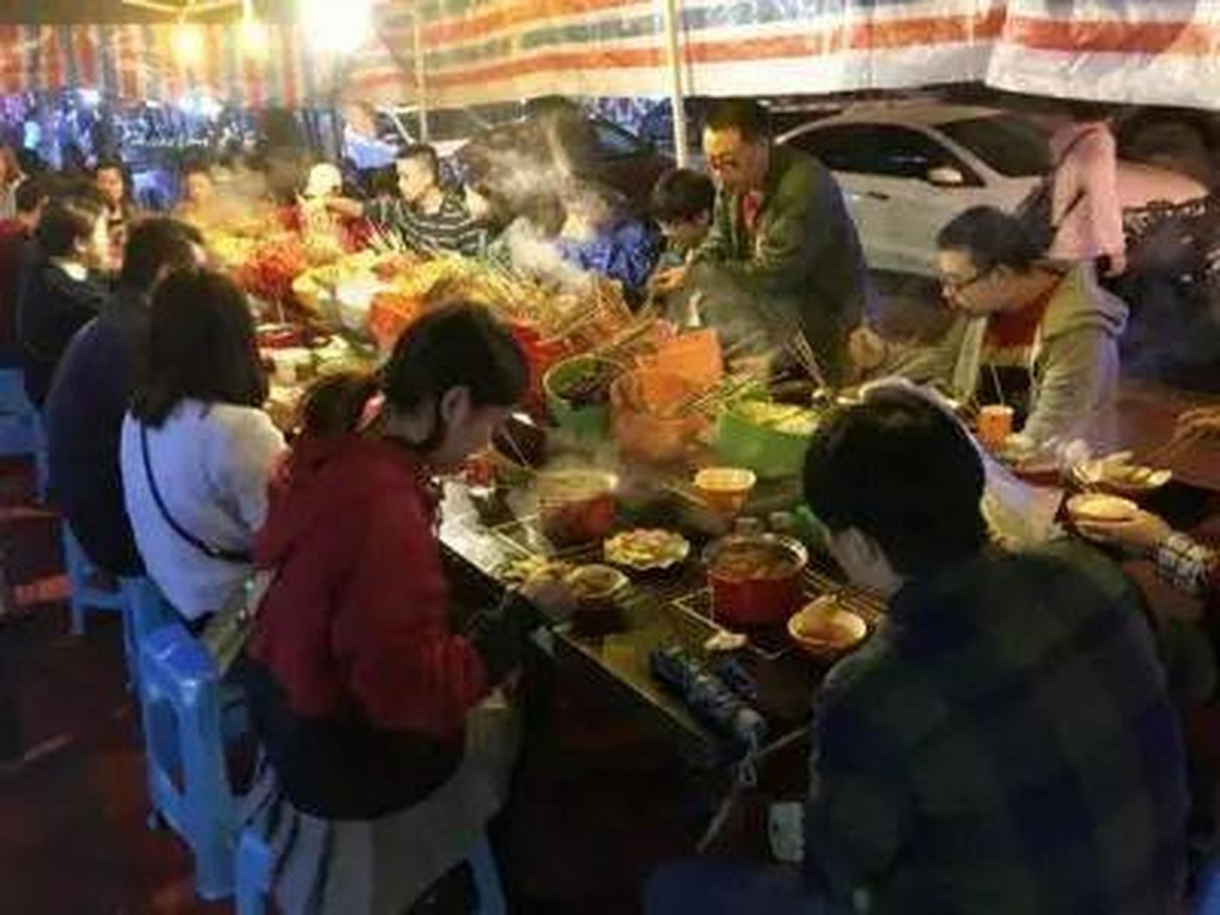 一张重庆生活照,重庆街头最出名的要数麻辣烫了,一大桌人围在一起吃