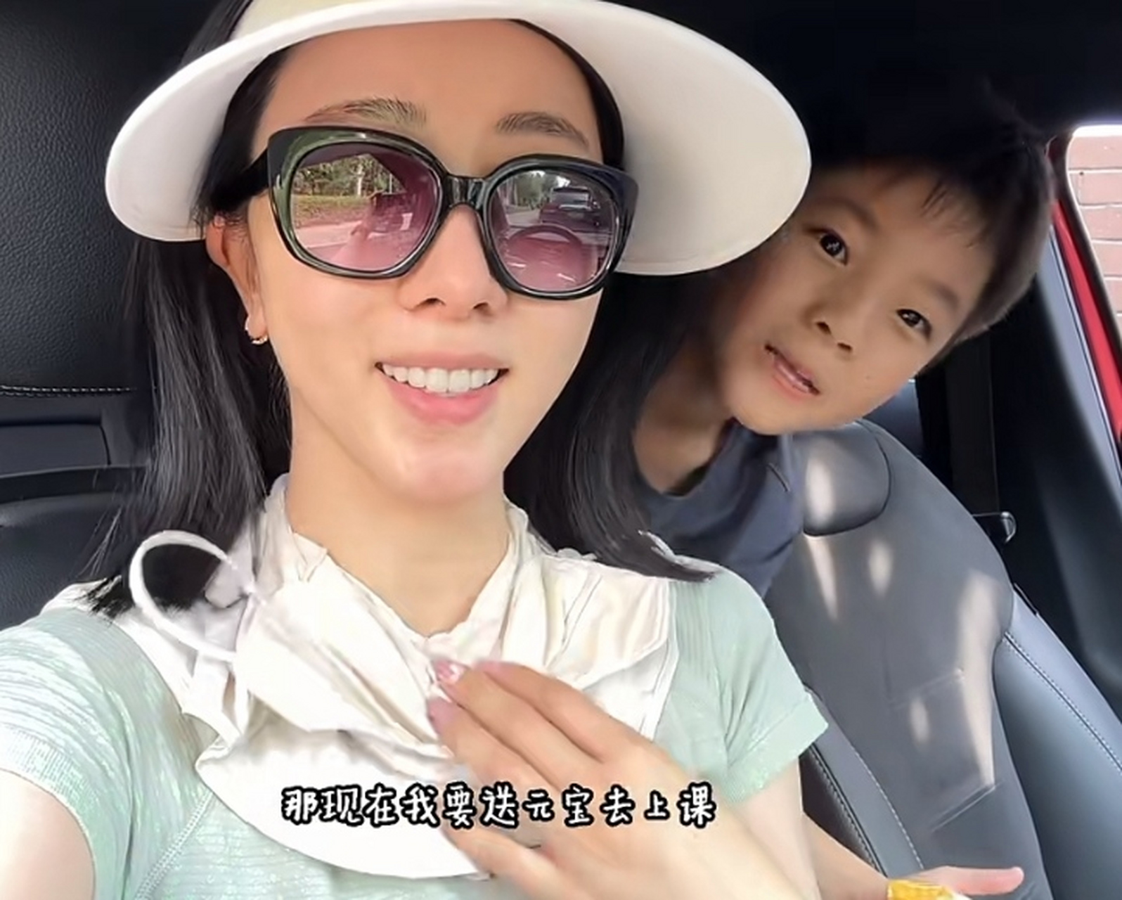 李思思开车送儿子去上课,元宝探着脑袋看镜头调皮又可爱,小家伙长得像