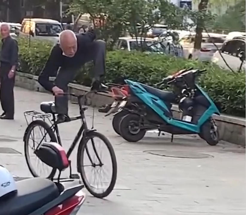 江苏大爷站在自行车上单手骑车,边上大爷看愣住了,够炫酷!