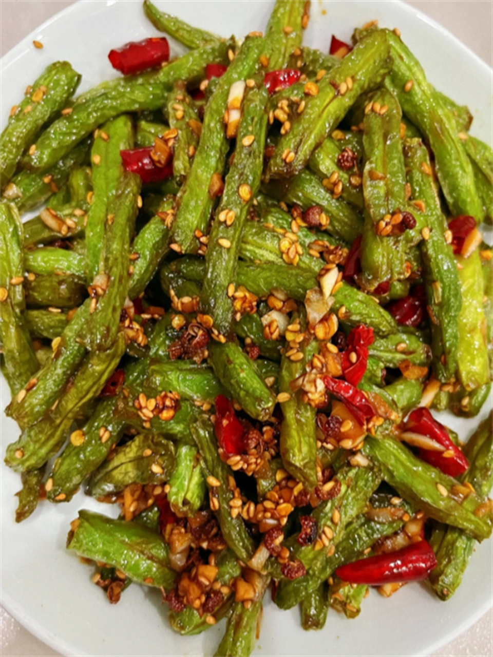 下面是干煸豆角的具体做法: 所需材料: 豆角:500克 干辣椒:10个 蒜:3