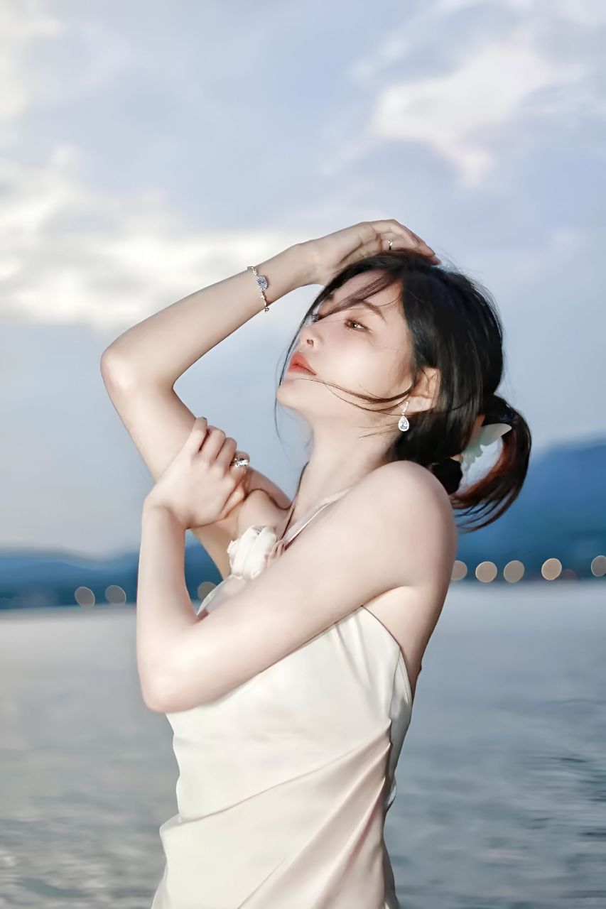 许佳琪身着挂脖玫瑰装饰开叉连衣裙,在晚霞的映衬下拍摄了一组唯美