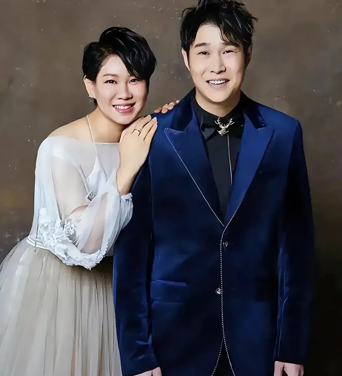 照片中的小沈阳西装打扮很帅,妻子沈春阳瘦了不少,穿着纺纱白裙僚着