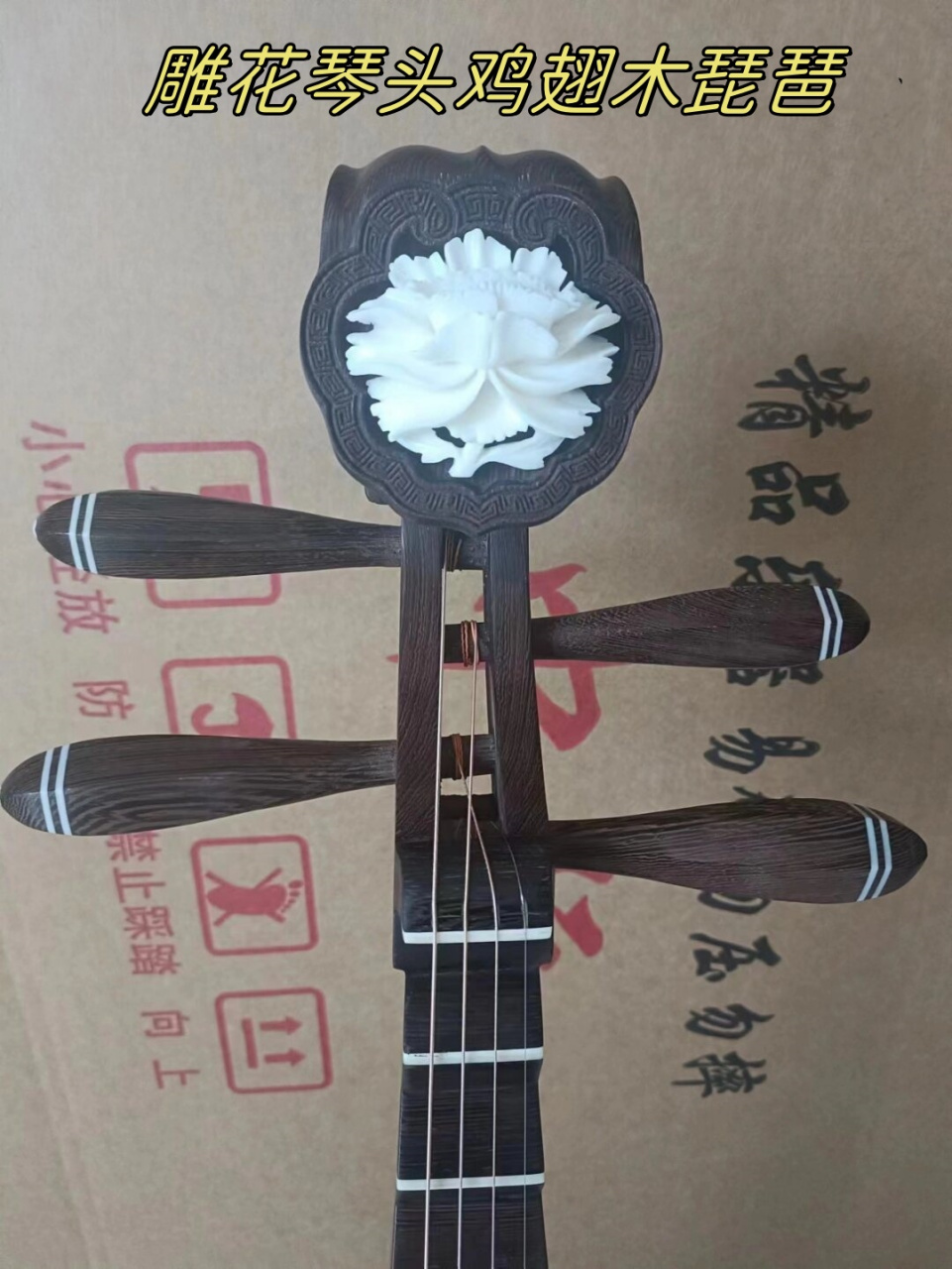 雕花琴头鸡翅木琵琶  这把琵琶颜色深沉又带着一丝华美,摸上去滑滑的