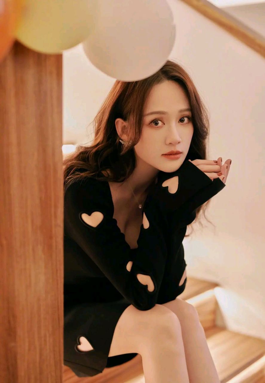 照片中的陈乔恩身穿黑色镂空裙,笑容甜美.