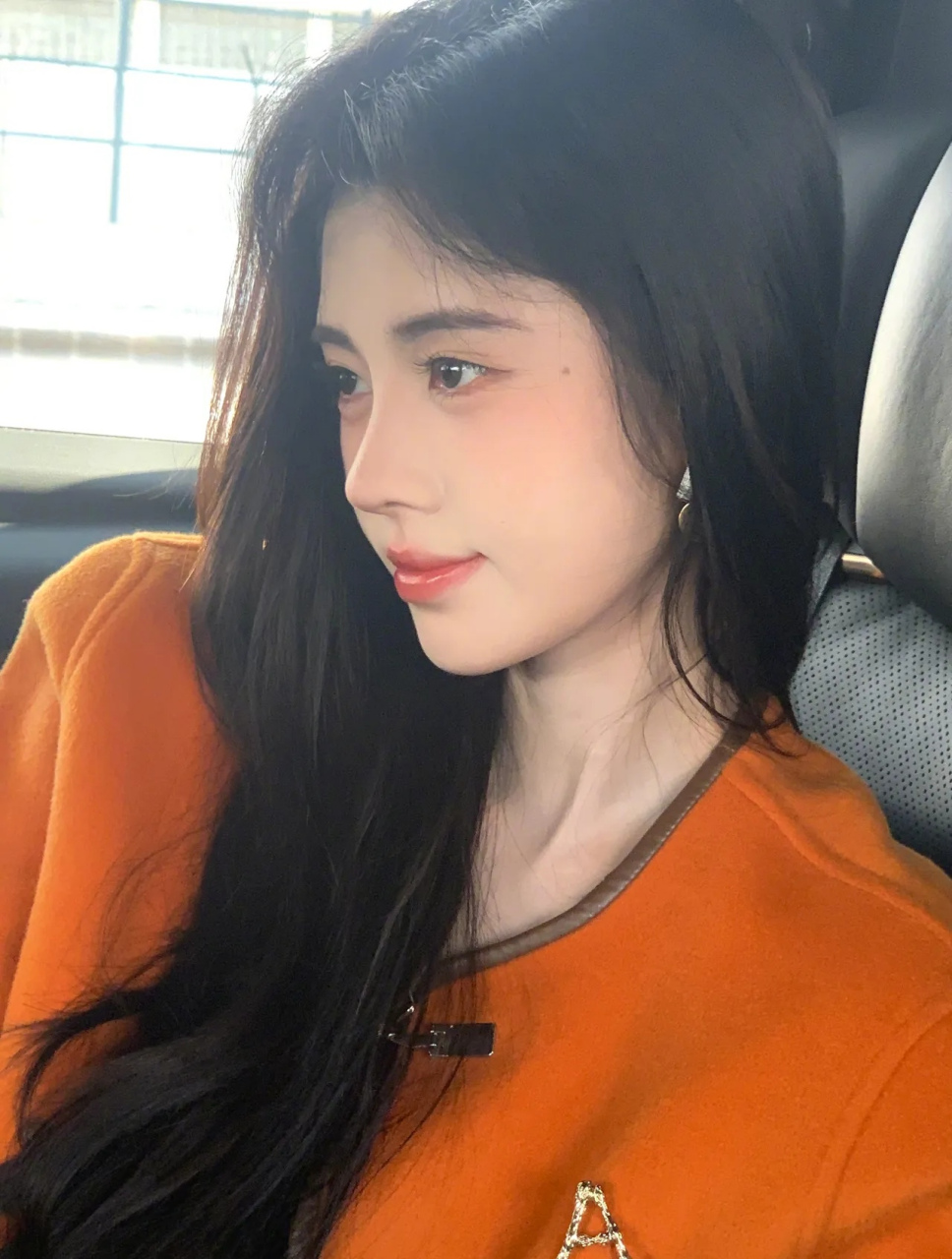 美女鞠婧祎,一袭橙色小西装,坐在车后座,她微笑着向镜头鞠躬,精致的