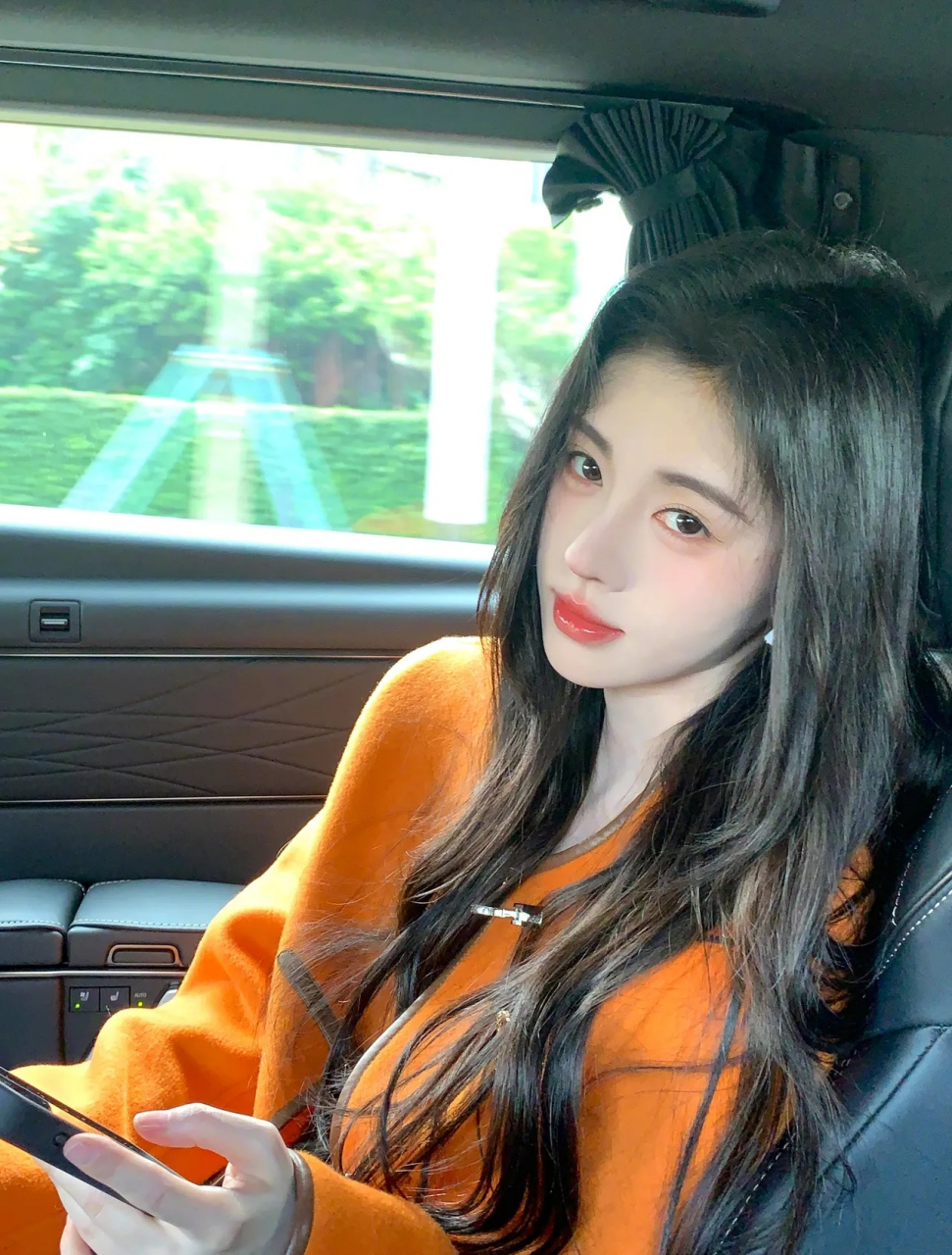 美女鞠婧祎,一袭橙色小西装,坐在车后座,她微笑着向镜头鞠躬,精致的