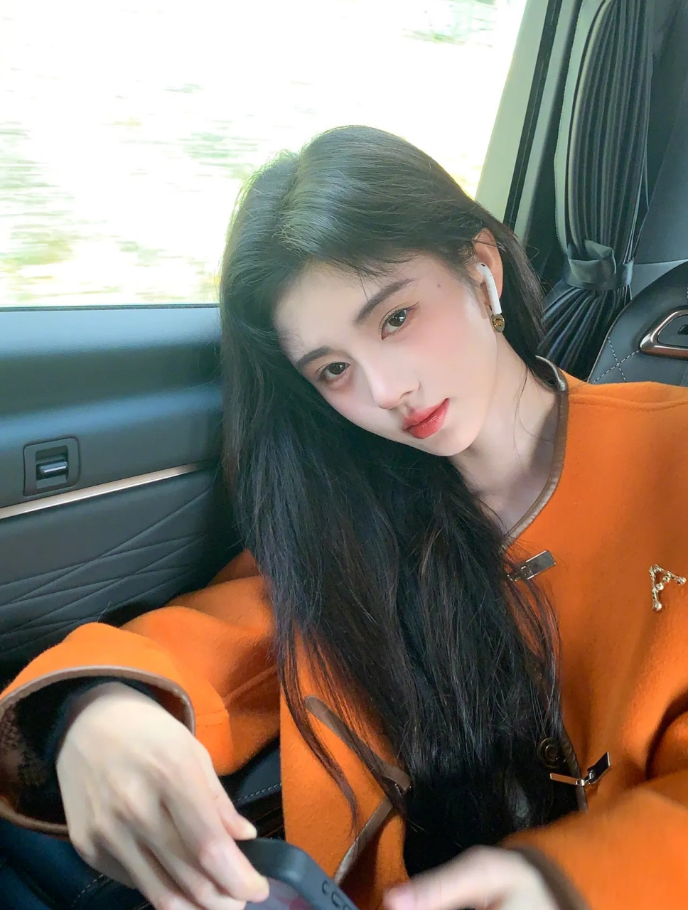 美女鞠婧祎,一袭橙色小西装,坐在车后座,她微笑着向镜头鞠躬,精致的