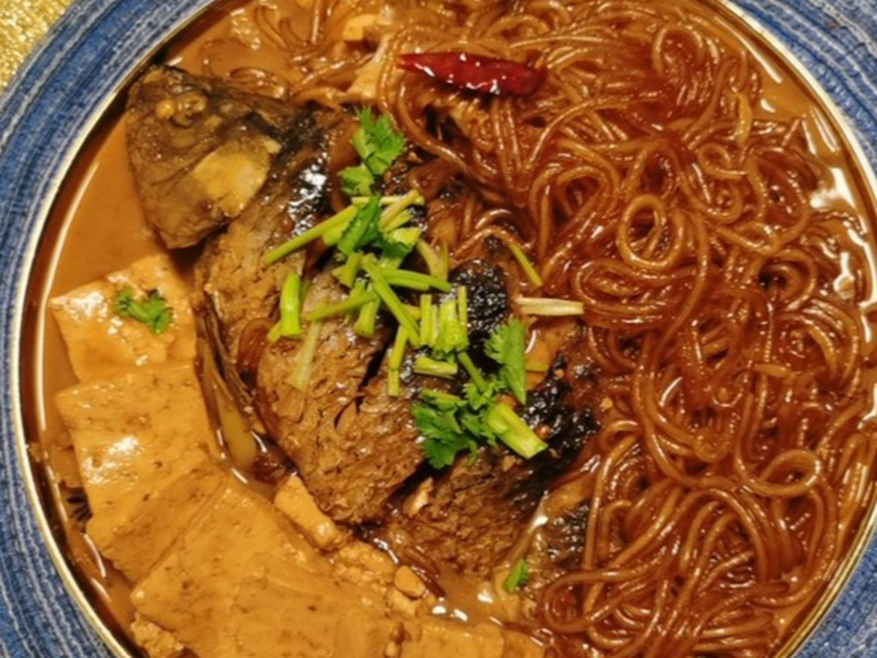 得莫利炖鱼是东北传统名菜,以鲤鱼,豆腐,粉条为主料,经过煎煮炖,调料