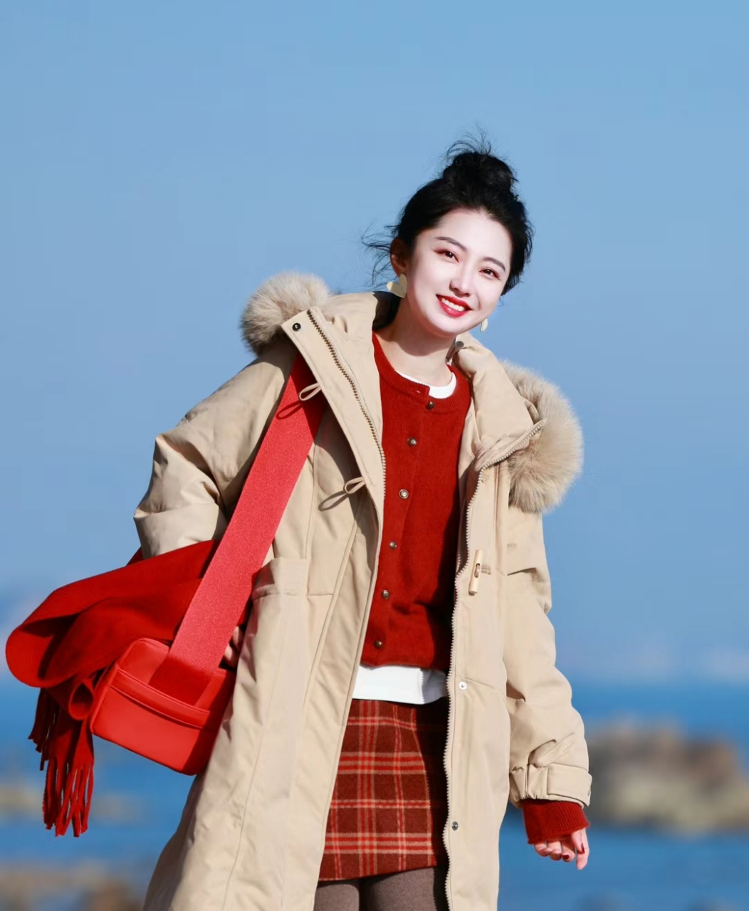 而红色格纹短裙则是极具少女感的单品,与杏色羽绒服搭配在一起,既显得