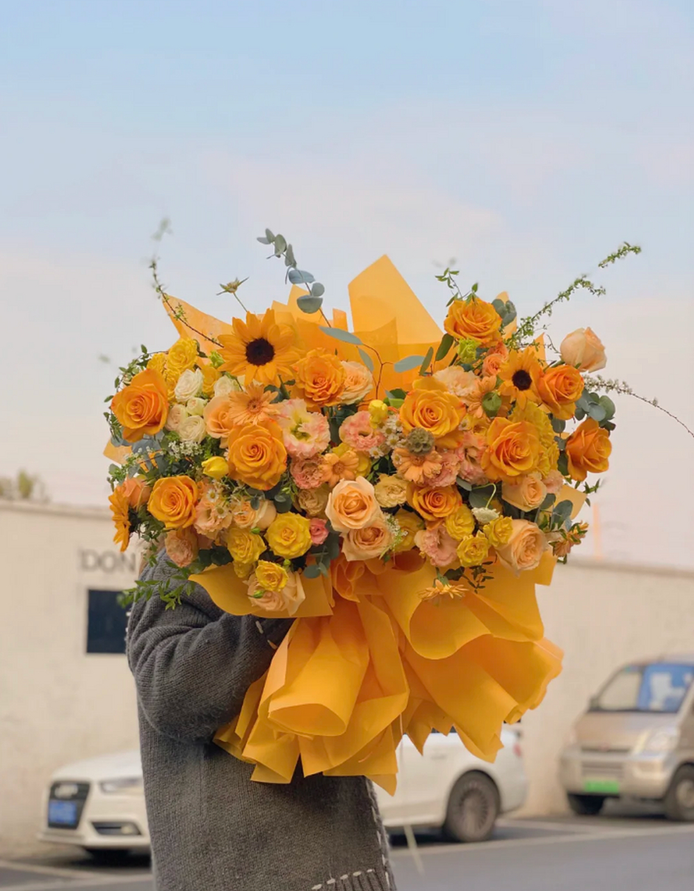 光影中的热烈拥抱:橙色系熊抱花束 这款花束以橙色为主调,如同初升的