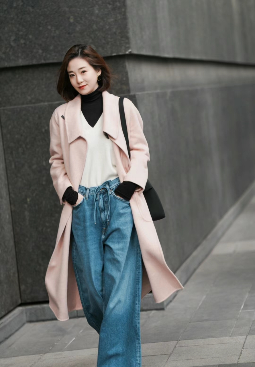 粉色大衣叠穿v领设计的白色针织衫,再叠穿黑色高领毛衣,搭配蓝色牛仔