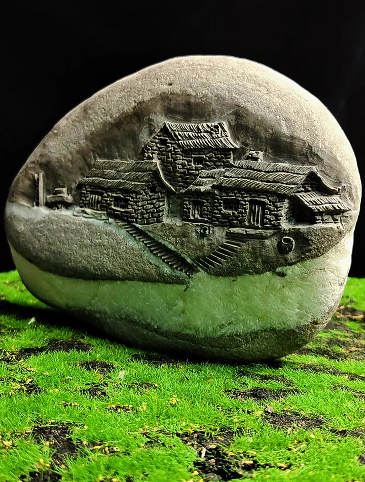 平平的鹅卵石,在上面用浮雕手法雕刻一个小山村