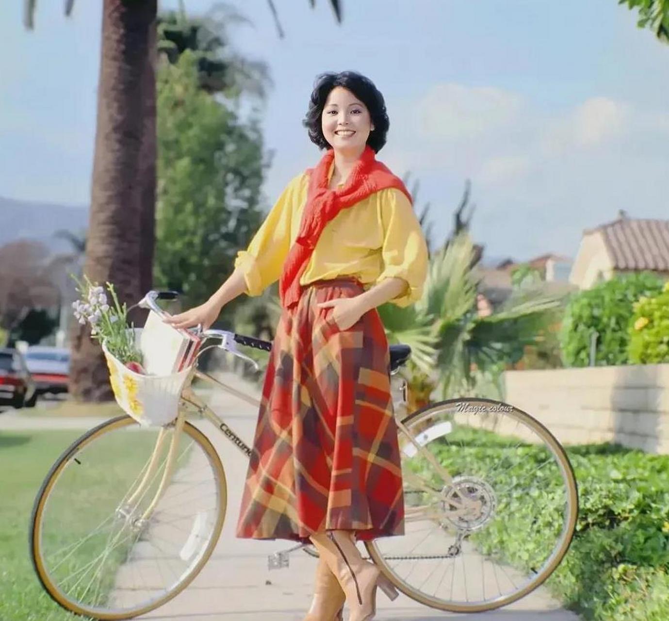 推着一辆自行车的邓丽君,那时候的邓丽君还很年轻,留着齐耳短发,穿着