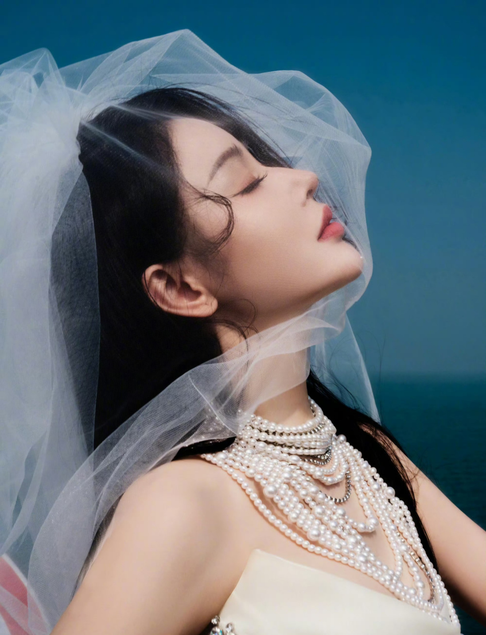 张天爱身披白裙,抹胸设计展露迷人锁骨,头披纱巾如仙子降临凡间,美不