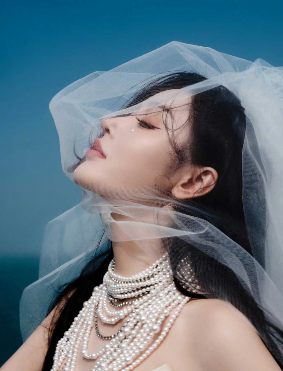 张天爱身披白裙,抹胸设计展露迷人锁骨,头披纱巾如仙子降临凡间,美不