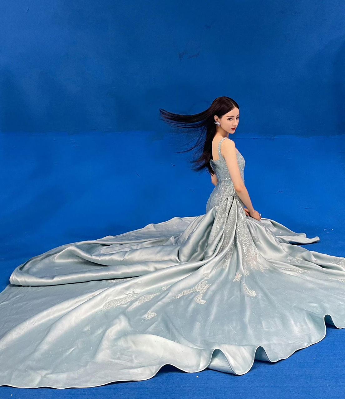 迪丽热巴身披蓝色礼裙,宛如仙境中的精灵,黑长直中分发型搭配眉眼缱绻