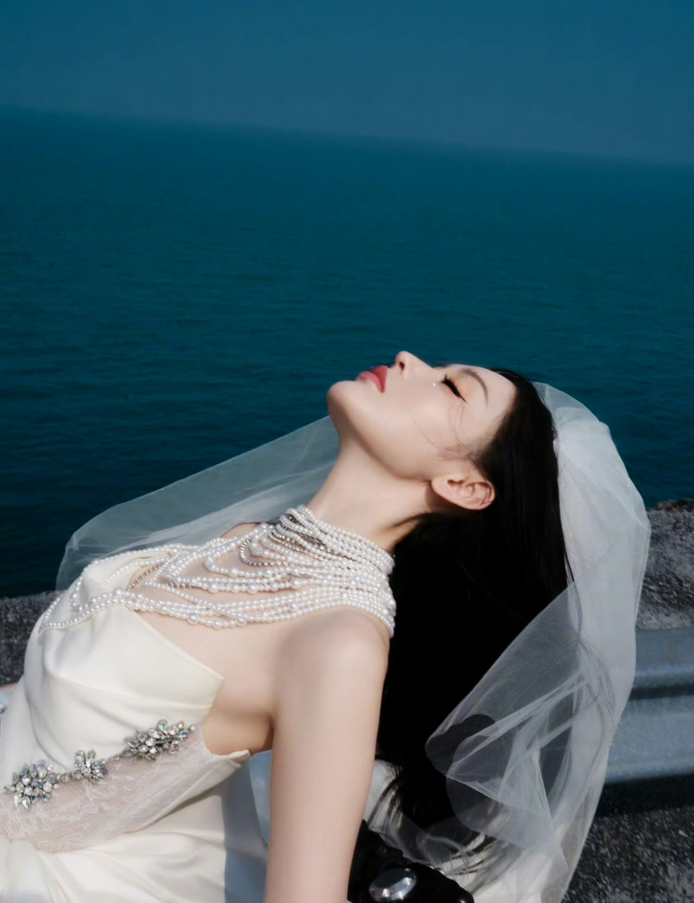 张天爱身披白裙,抹胸设计展露迷人锁骨,头披纱巾如仙子降临凡间,美不