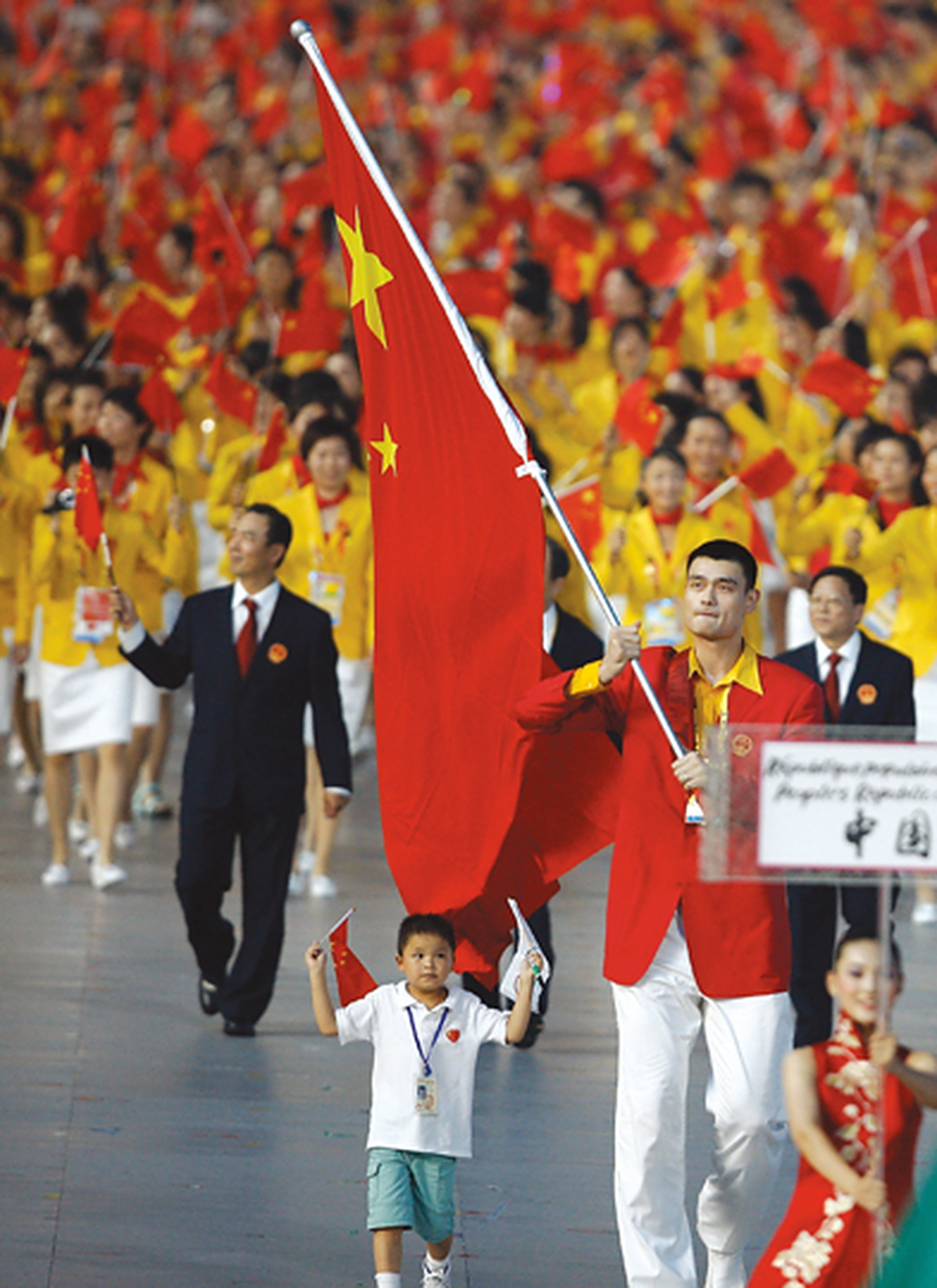 2008年奥运会开幕式上,姚明高举红旗走在人群正前方