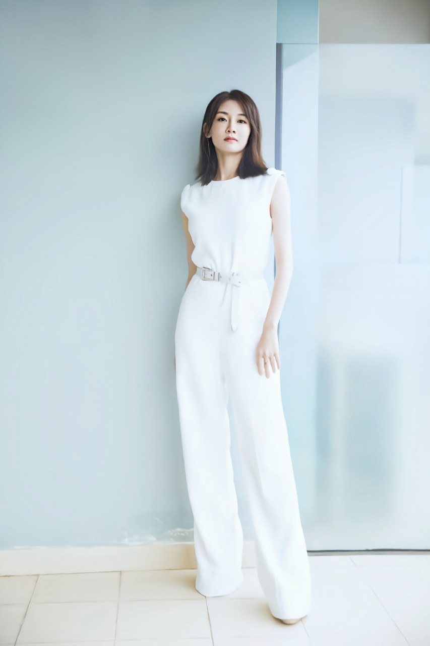 她身穿一件白色长裙,展现出她的优雅和女性魅力.