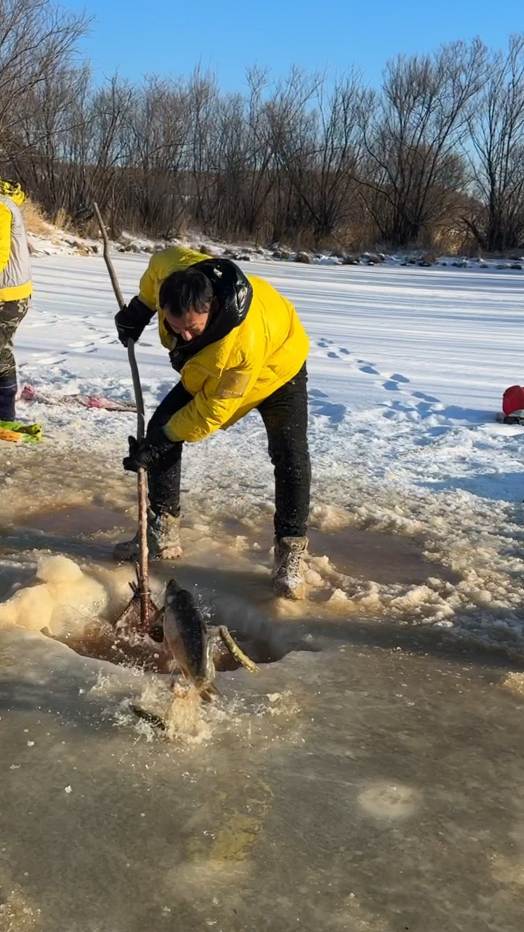 东北人冬季冰窟窿里捞鱼场景